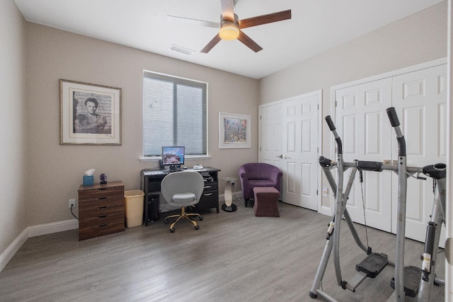 office featuring a ceiling fan, baseboards, visible vents, and wood finished floors