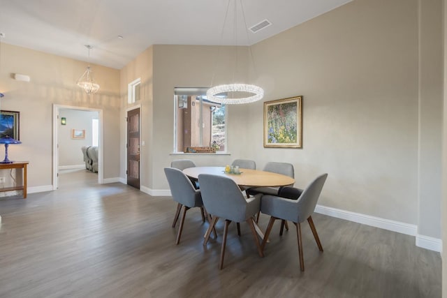 dining space with baseboards, visible vents, and wood finished floors