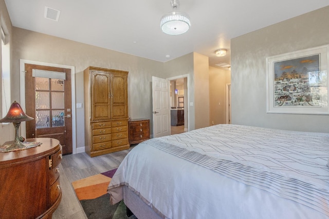 bedroom featuring wood finished floors and visible vents