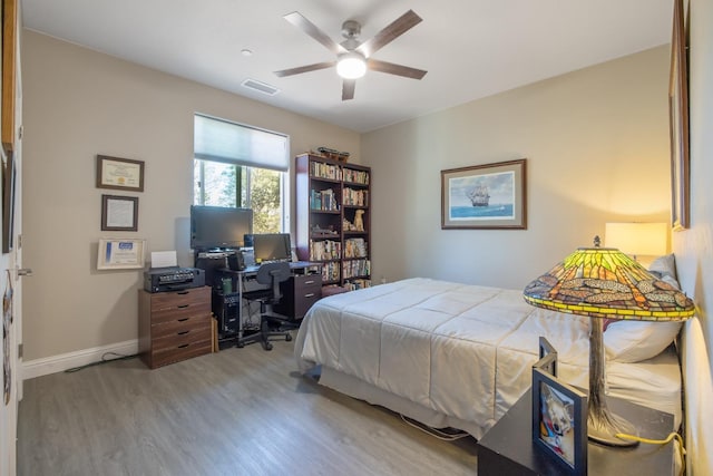 bedroom featuring ceiling fan, light wood-type flooring, visible vents, and baseboards