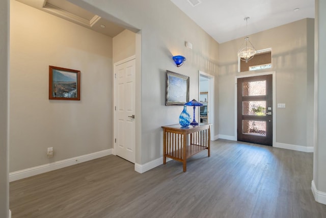 foyer with an inviting chandelier, baseboards, and wood finished floors