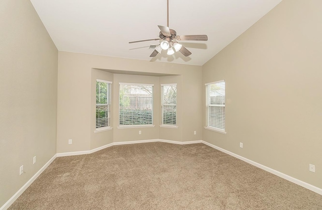 unfurnished room with carpet floors, baseboards, vaulted ceiling, and a ceiling fan