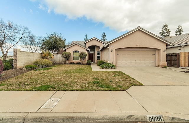 view of front of property featuring concrete driveway, an attached garage, fence, a front lawn, and stucco siding