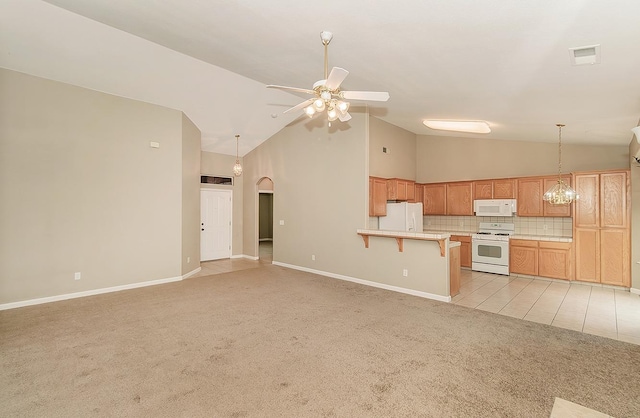 kitchen featuring arched walkways, a breakfast bar, light countertops, light carpet, and white appliances