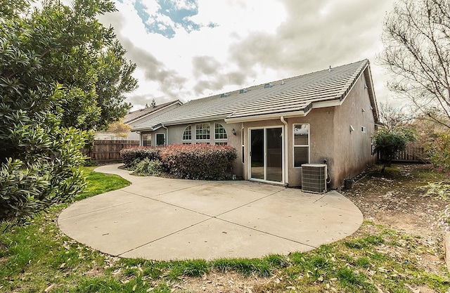 back of house featuring a tile roof, a patio, stucco siding, fence, and cooling unit