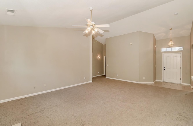 unfurnished room with light colored carpet, visible vents, a ceiling fan, vaulted ceiling, and baseboards