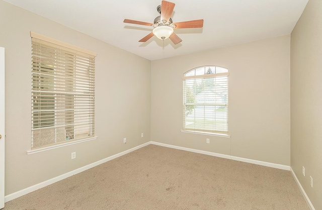 spare room with carpet floors, ceiling fan, and baseboards