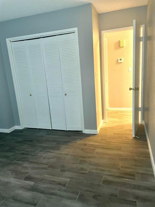 hall with dark wood-style floors and baseboards