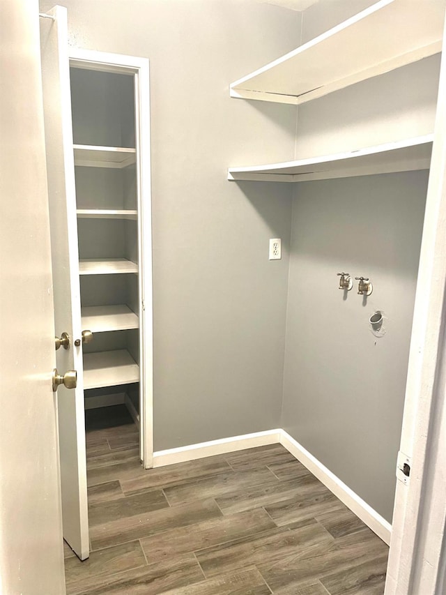 laundry room with laundry area, baseboards, and wood finished floors