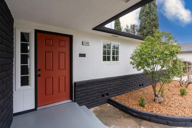 doorway to property featuring stucco siding