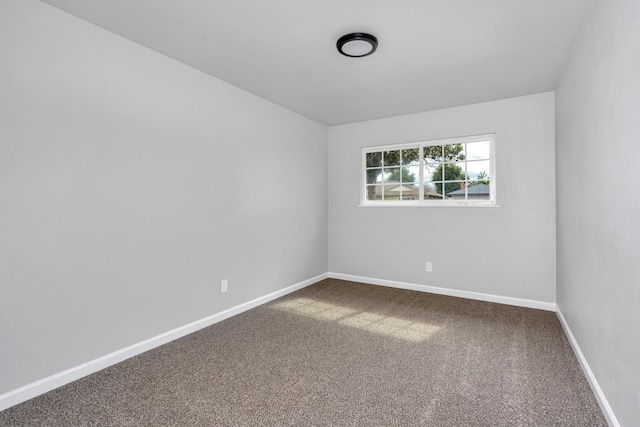 spare room featuring carpet floors and baseboards