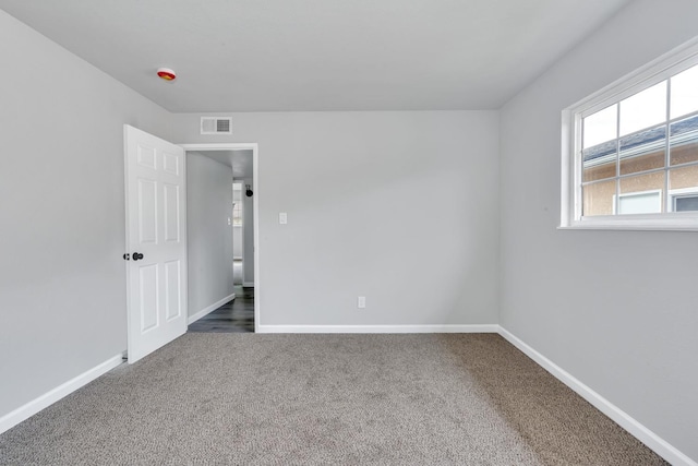 unfurnished bedroom with carpet floors, visible vents, and baseboards