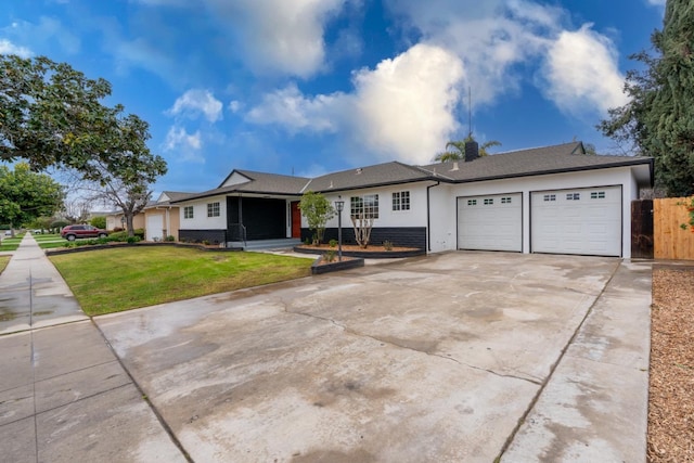 ranch-style home featuring a garage, driveway, fence, a front lawn, and stucco siding