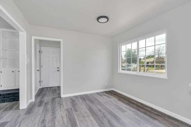 empty room featuring baseboards and wood finished floors