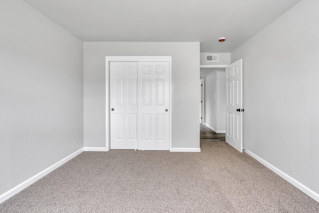 unfurnished bedroom featuring carpet floors, a closet, visible vents, and baseboards