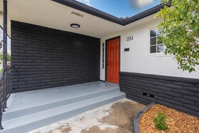 entrance to property featuring crawl space and stucco siding