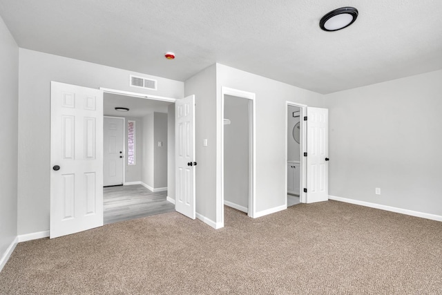 unfurnished bedroom featuring carpet floors, baseboards, and visible vents