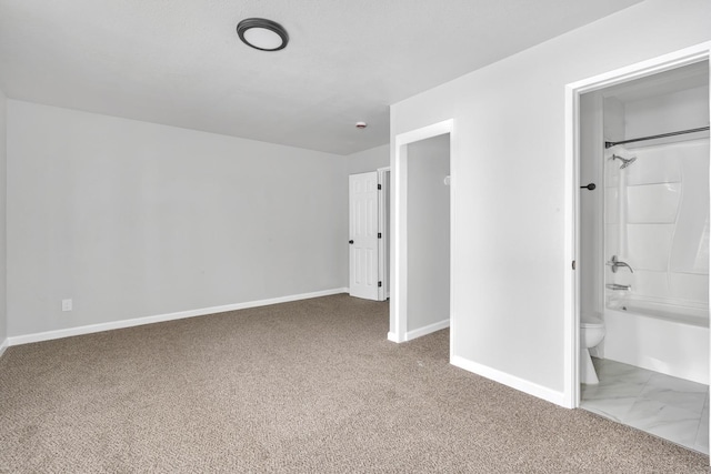 unfurnished bedroom with carpet floors, ensuite bath, and baseboards