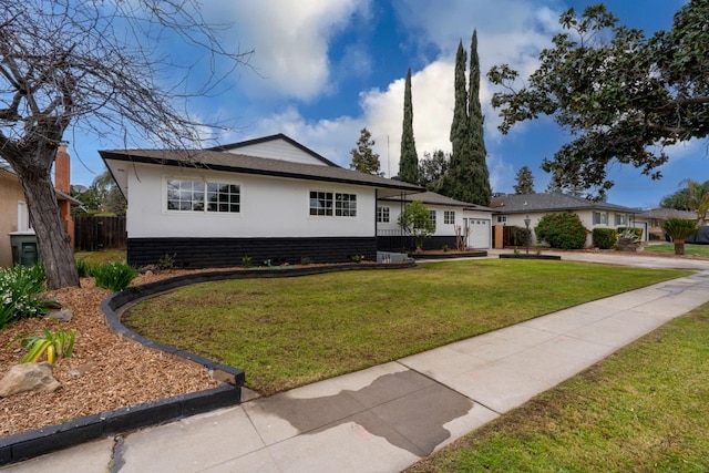 view of front of property with a garage, driveway, fence, and a front lawn