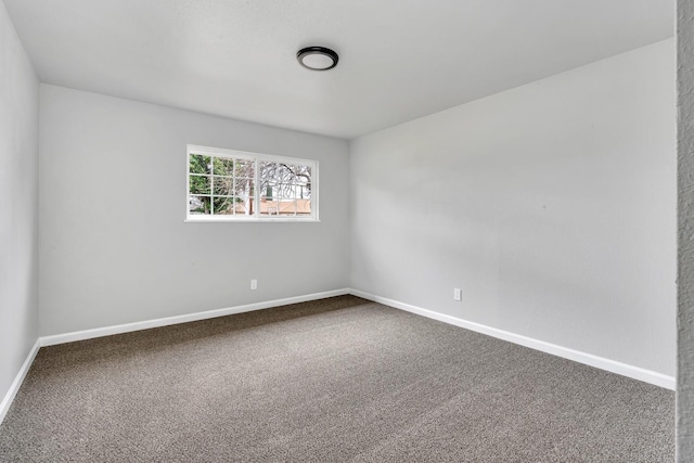 carpeted spare room featuring baseboards