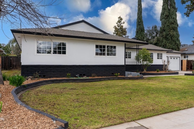 view of front facade with a garage, a front lawn, fence, and stucco siding