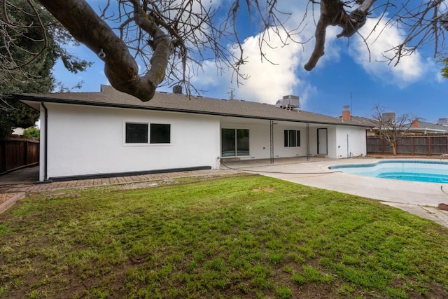 rear view of property with a patio area, a fenced backyard, a yard, and stucco siding