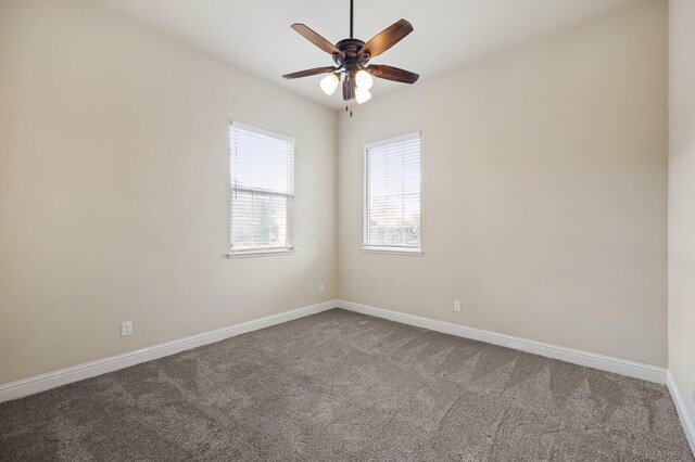 carpeted spare room with ceiling fan and baseboards