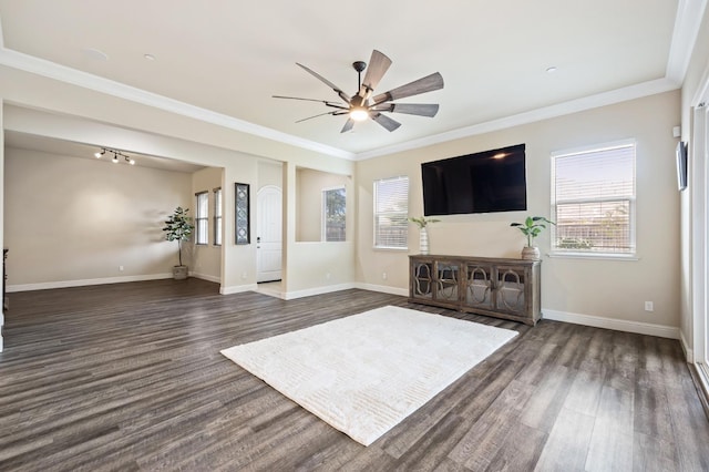unfurnished living room with baseboards, ornamental molding, ceiling fan, and dark wood-type flooring