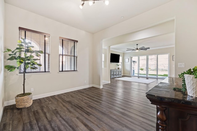 living area featuring a ceiling fan, dark wood finished floors, and baseboards