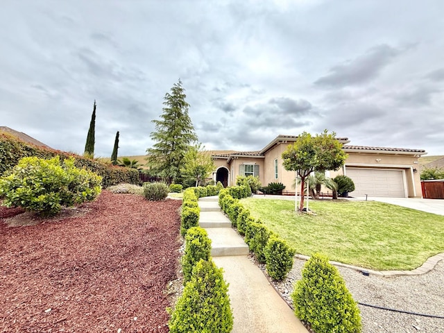 view of front facade featuring a tile roof, a front lawn, stucco siding, driveway, and an attached garage