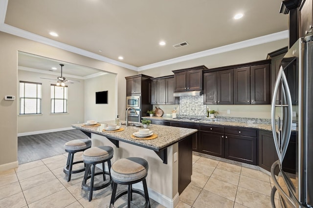 kitchen with light tile patterned floors, visible vents, appliances with stainless steel finishes, and light stone counters