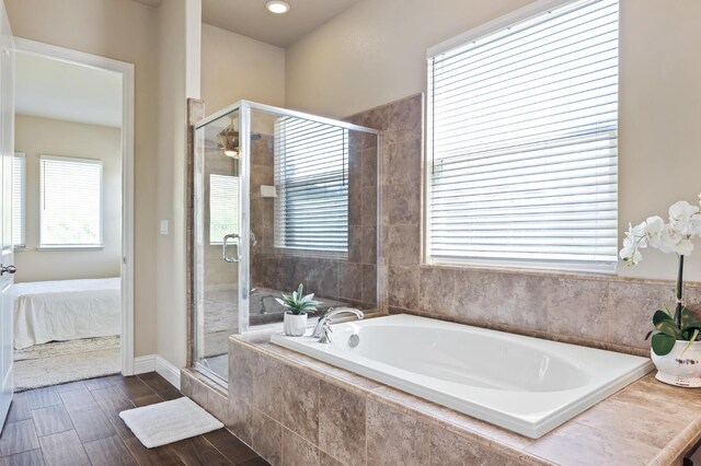 ensuite bathroom featuring a stall shower, a garden tub, and connected bathroom