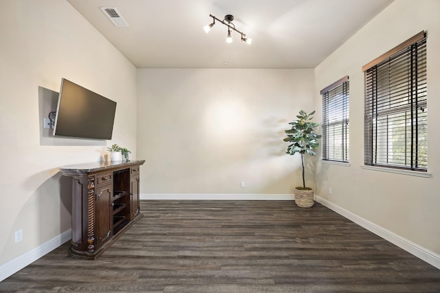 interior space with baseboards, visible vents, and wood finished floors