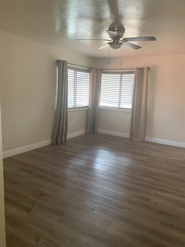 spare room featuring ceiling fan, baseboards, and wood finished floors