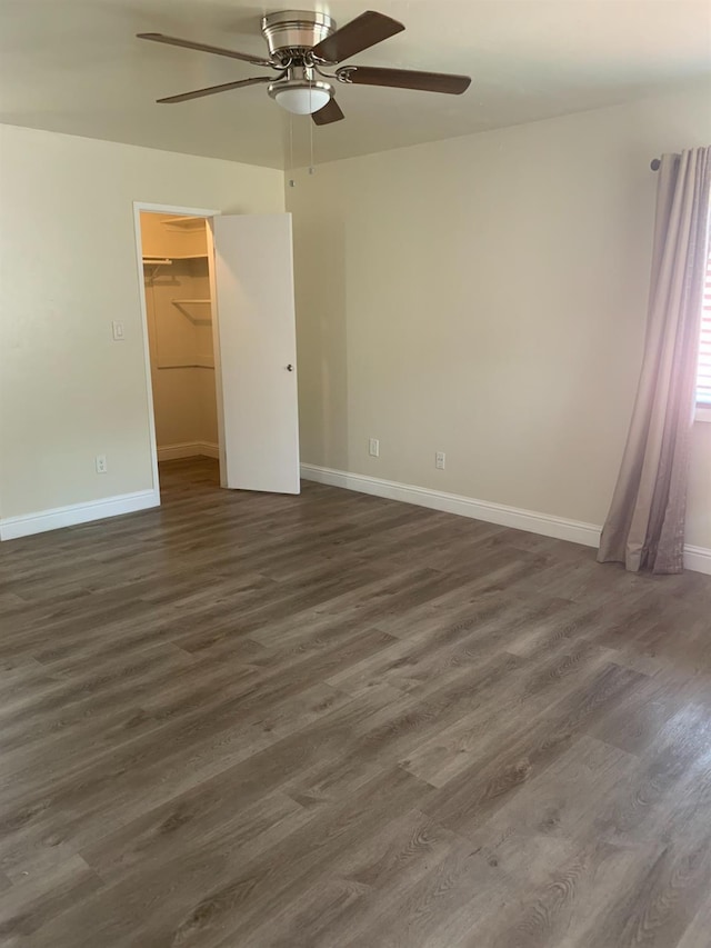 unfurnished room with dark wood finished floors, baseboards, and ceiling fan