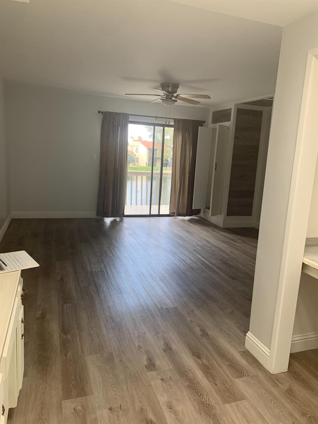 unfurnished room featuring wood finished floors, a ceiling fan, and baseboards