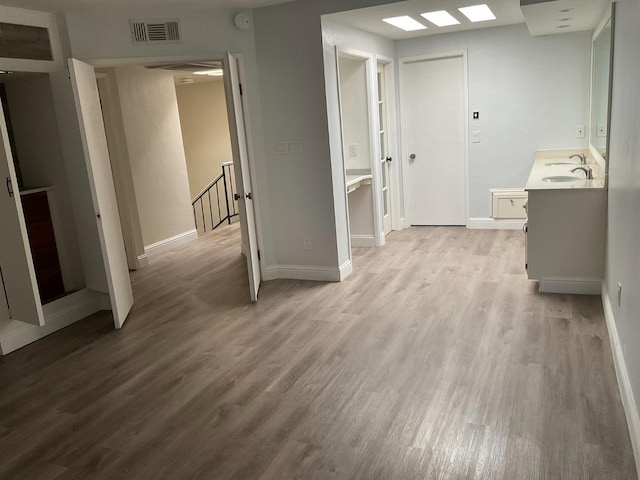 bathroom with a sink, baseboards, visible vents, and wood finished floors