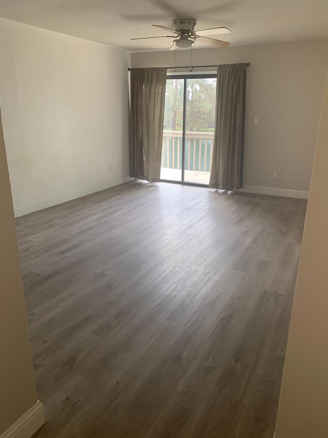 empty room featuring a ceiling fan, baseboards, and wood finished floors