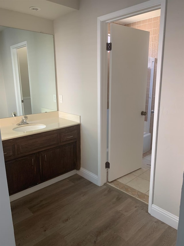 bathroom featuring vanity, baseboards, and wood finished floors