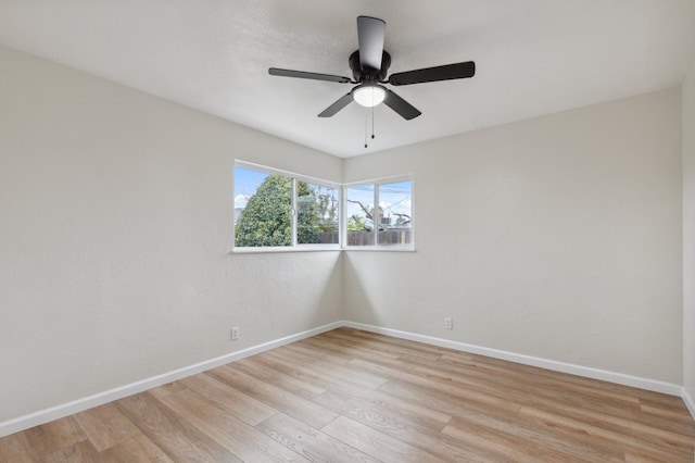 spare room with light wood-type flooring, baseboards, and ceiling fan