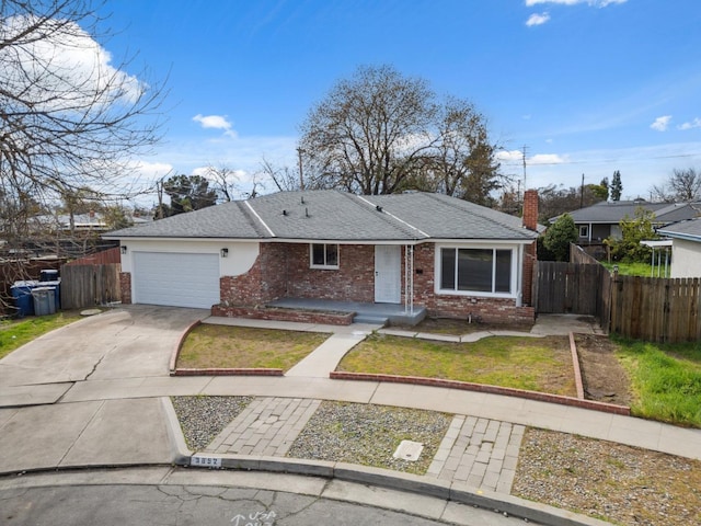 view of front of home featuring driveway, fence, brick siding, a garage, and a front yard