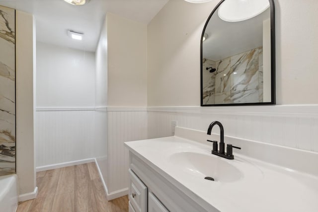 bathroom with wainscoting, vanity, wood finished floors, and a shower