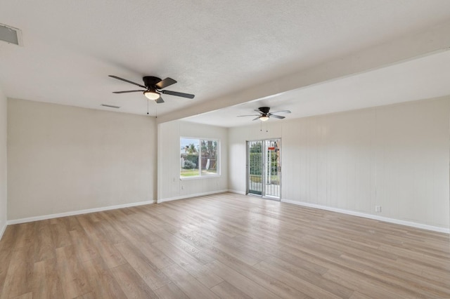 empty room with visible vents, light wood finished floors, baseboards, and a ceiling fan