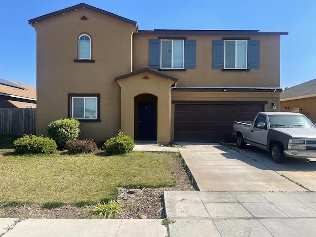 view of front of house featuring a garage, concrete driveway, stucco siding, fence, and a front yard