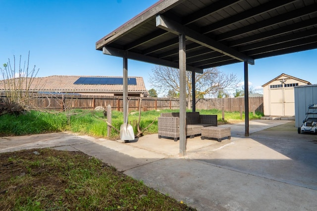 view of patio featuring a storage shed, a fenced backyard, and an outbuilding