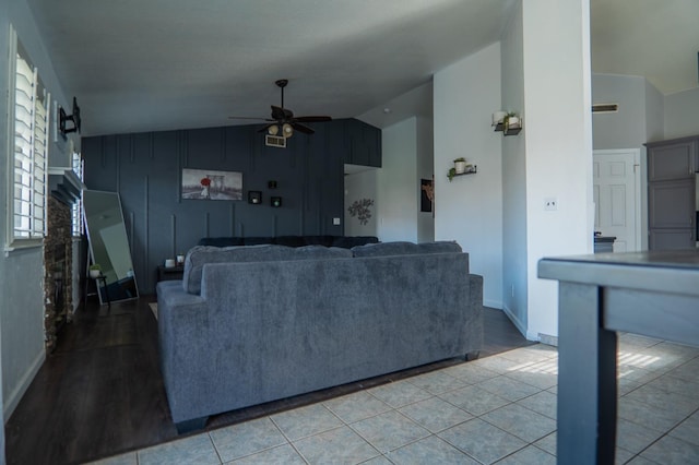 living room with ceiling fan, lofted ceiling, and tile patterned floors