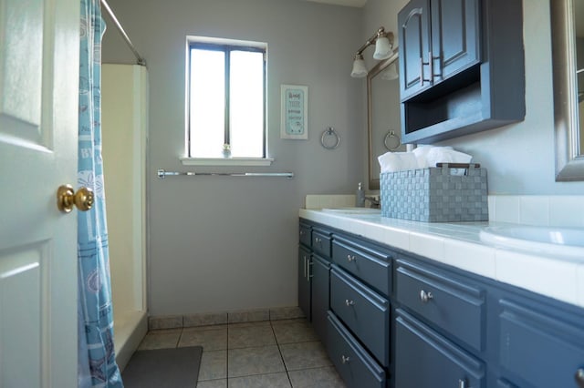 full bathroom with tile patterned flooring, a shower with shower curtain, a sink, baseboards, and double vanity