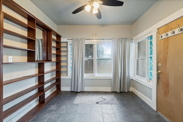 interior space featuring baseboards and a ceiling fan