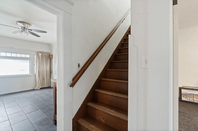 stairs featuring ceiling fan and tile patterned floors