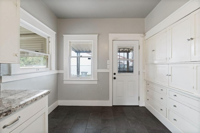 doorway to outside featuring a healthy amount of sunlight and baseboards